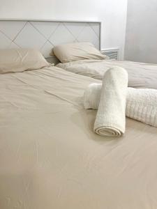 a white bed with two pillows and a towel on it at Petit Paradis au cœur de Jérusalem in Jerusalem