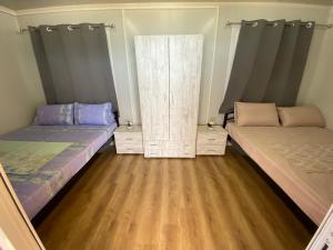 2 letti in una camera con pavimenti in legno di Camping Anamour a Toroni