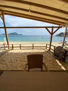a chair on a beach with the ocean in the background at Camping Anamour in Toroni