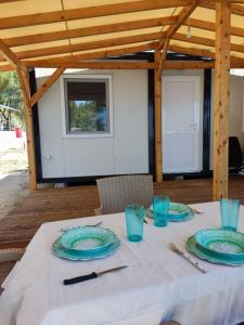 una mesa con placas azules sobre un mantel blanco en Camping Anamour, en Toroni