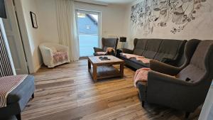 a living room with two couches and a person sitting in a chair at Träumerei Veitsch in Veitsch