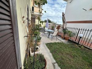 een patio met een tafel en stoelen en een hek bij B&B Love - HOLIDAY HOUSE- Casa Vacanza Santa Severa in Santa Severa