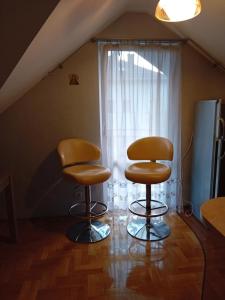 two chairs sitting in a room with a window at Orkana44F in Mszana Dolna