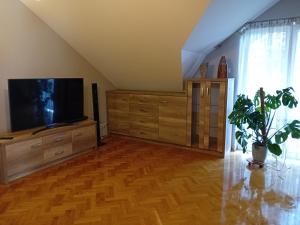 a living room with a flat screen tv and a wooden floor at Orkana44F in Mszana Dolna