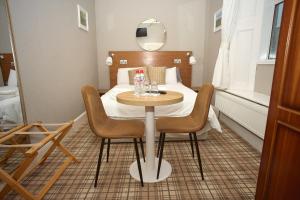a room with a table and a bed with a mirror at Five Glens Inn -North West Ireland Touring Base in Manorhamilton