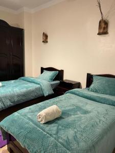 Habitación con 2 camas y toalla. en Moonlight en Dahab