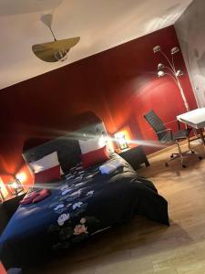 una camera con un grande letto con una parete rossa di Comme à la maison a Elne
