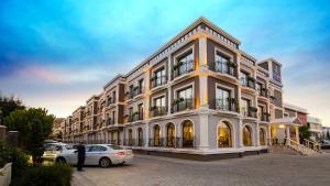 a large building with cars parked in front of it at Svalinn Hotel in Izmir