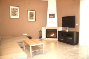 sala de estar con chimenea y TV en Rincón EL ENCANTO de Aracena, en Aracena