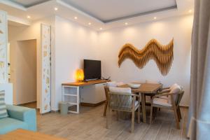 a dining room with a table and a television at VILLA KASABLANCA in Skala Rachoniou