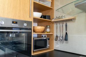 a kitchen with a stove and a microwave at VILLA KASABLANCA in Skala Rachoniou