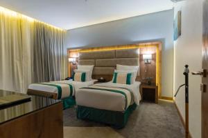 a hotel room with two beds in a room at Rasia Hotel Jeddah in Jeddah