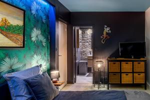 隆瑞莫的住宿－Sunset Appart-Hotel 3 chambres, 2 Salles de Bain, proche Paris, Massy & Orly，一间卧室配有一张床,墙上拥有蓝色的灯光