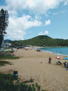 uma praia com um monte de pessoas nela em Praia, Sol, luar e lazer em Itapema