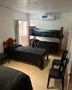 una camera con tre letti e una sedia e una finestra di Departamento 3 ambientes a Bella Vista