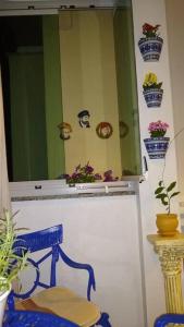 uma cadeira azul em frente a um espelho com vasos de plantas em Praia, Sol, luar e lazer em Itapema