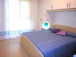 ein Schlafzimmer mit einem großen Bett mit einer blauen Decke in der Unterkunft Apartment Gemini con Piscina in Bibione