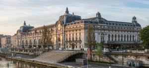 a large building with a bridge next to a river at Love Nest in Saint-Michel in Paris