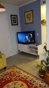 uma sala de estar com uma televisão de ecrã plano num quarto em Praia, Sol, luar e lazer em Itapema