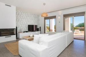 a living room with a white couch and a tv at Villa in Ibiza Town sleeps 10 - Ses Llaneres in Ibiza Town