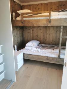 a bedroom with two bunk beds and a wooden wall at Sentral leilighet på Geilo in Geilo