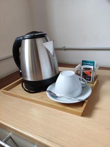 a tea kettle and aucer on a wooden table at Albergo Caffaro in Genoa