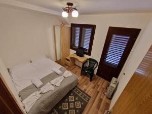 a bedroom with a bed and a desk with a television at Dursi Home in Drajna de Sus