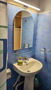 a bathroom with a sink and a mirror at Ultracentral Lozonschi Apartament Parter in Iaşi