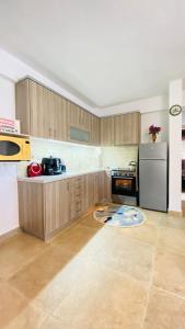 a kitchen with wooden cabinets and a stainless steel refrigerator at LUNA'S HOUSE in Asprovalta