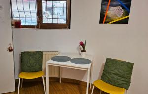 a table with two chairs and a table with flowers on it at Ultracentral Lozonschi Apartament Parter in Iaşi