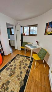 - un salon avec une table, des chaises et un tapis dans l'établissement Ultracentral Lozonschi Apartament Parter, à Iaşi