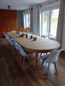 una gran mesa de madera con sillas alrededor en Ama's Sweet home, en Saint-Hubert