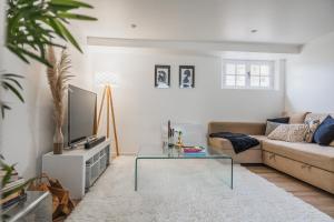 a living room with a couch and a glass coffee table at Maison Zola in Fleury-les-Aubrais