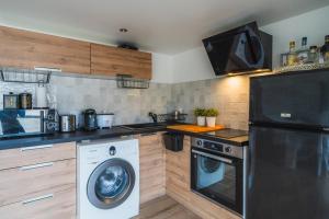 a kitchen with a washing machine and a washer at Maison Zola in Fleury-les-Aubrais +25 photos