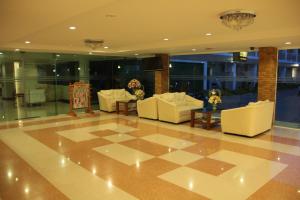 un vestíbulo con sofás blancos y suelo a cuadros en That Phanom River View Hotel, en That Phanom