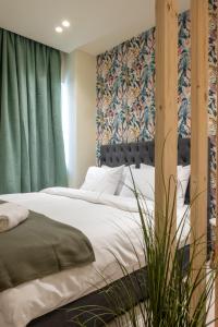 - une chambre avec un lit doté d'une tête de lit et de rideaux verts dans l'établissement Monastiraki Urban Studio, à Athènes