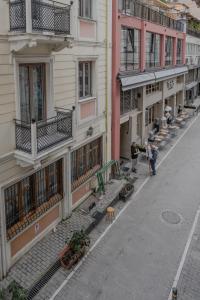 Une rue vide avec des bâtiments et des gens qui marchent sur le trottoir dans l'établissement Monastiraki Urban Studio, à Athènes