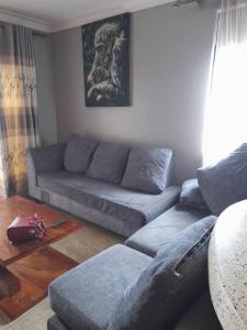 Nelly Apartments في Mbale: غرفة معيشة مع أريكة وطاولة