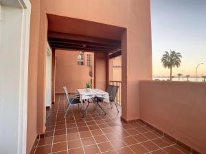 balkon ze stołem i krzesłami w budynku w obiekcie APARTAMENTO PLAYA LA VIÑA P w mieście Torremolinos