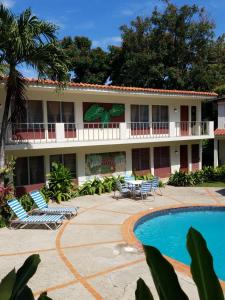 a resort with a swimming pool and chairs and a building at Casa Sylvie in Sosúa