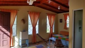 Zimmer mit Fenstern, einem Bett und einer Tür in der Unterkunft Casa Sylvie in Sosúa