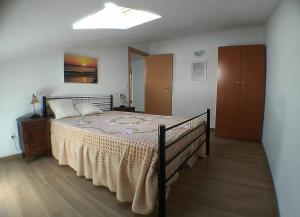 a bedroom with a bed with a blanket on it at Gala T1+ in Figueira da Foz
