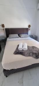 a bedroom with a bed with two towels on it at Ellis-Suites Nea Peramos Kavala in Nea Peramos