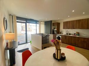 a kitchen with a table with a vase of flowers on it at Grand T3 dans le centre historique in Agen +12 photos
