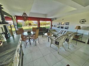 uma sala de estar com um sofá, mesas e cadeiras em Esturion de Montoya - La Barra - Punta del Este - 4 pasajeros em Punta del Este