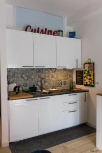 eine Küche mit weißen Schränken und einem Waschbecken in der Unterkunft Casina Mia,viale Orazio Flacco 5 Policlinico in Bari