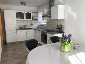 a kitchen with a table with purple flowers on it at feelslikehome Apartment Nähe Stuttgart Flughafen - Messe in Filderstadt