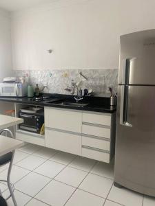 eine Küche mit einer Spüle und einem Kühlschrank aus Edelstahl in der Unterkunft Apartamento térreo próximo ao Shopping Iguatemi in Votorantim