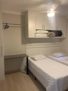 Zimmer mit 2 Betten und einem Tisch in der Unterkunft Apartamento térreo próximo ao Shopping Iguatemi in Votorantim