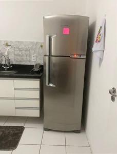 a stainless steel refrigerator with a pink sticker on it at Apartamento térreo próximo ao Shopping Iguatemi in Votorantim